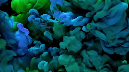 Colorful green, blue ink drops mixing in water