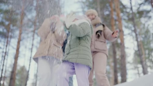 Fröhliche Familie spielt während der Wintersaison im verschneiten Wald