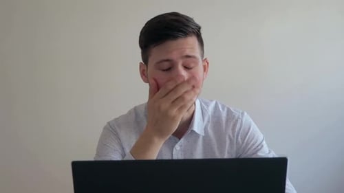 Stressed Young Adult Working on Laptop