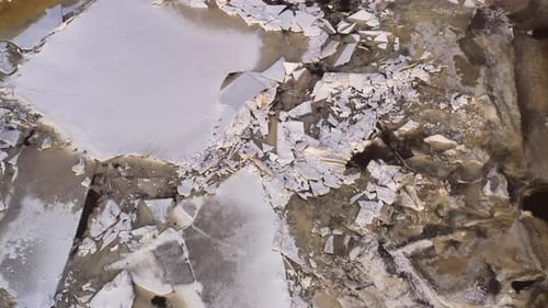 Ice drift, ice floes float on the river in early spring while melting, drone tilt down view
