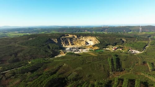 Aerial View of Quarry with Distant Wind Turbines