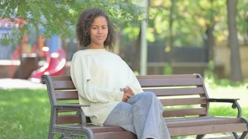 Young Woman Smiling and Posing on Park Bench