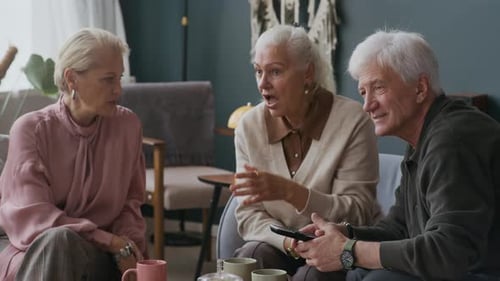 Seniors Chatting and Watching TV at Home