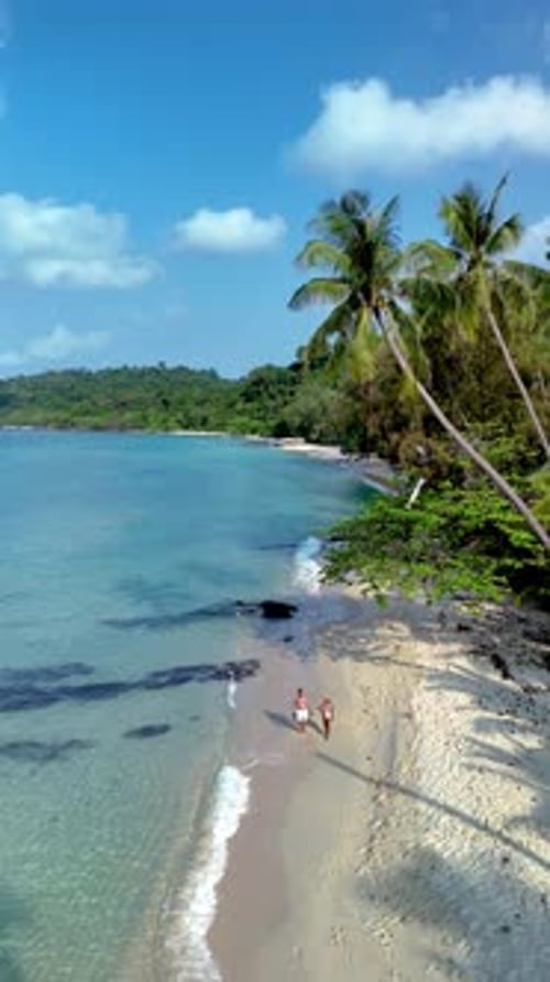 Enchanting Koh Kood Island Beach with Couples Strolling Along the Shore