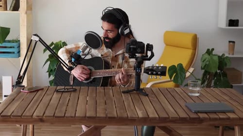 Man Singing and Playing Guitar for Recording