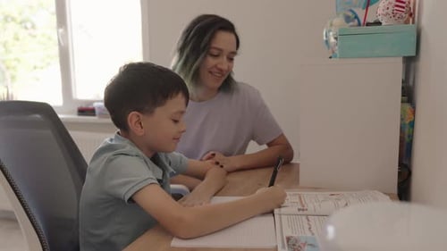 Child Doing Homework with Adult in Bright Home