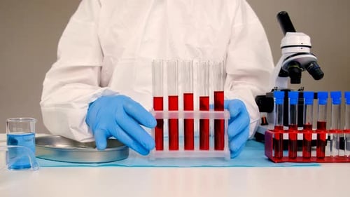 Scientist Handling Test Tubes in Laboratory Setting