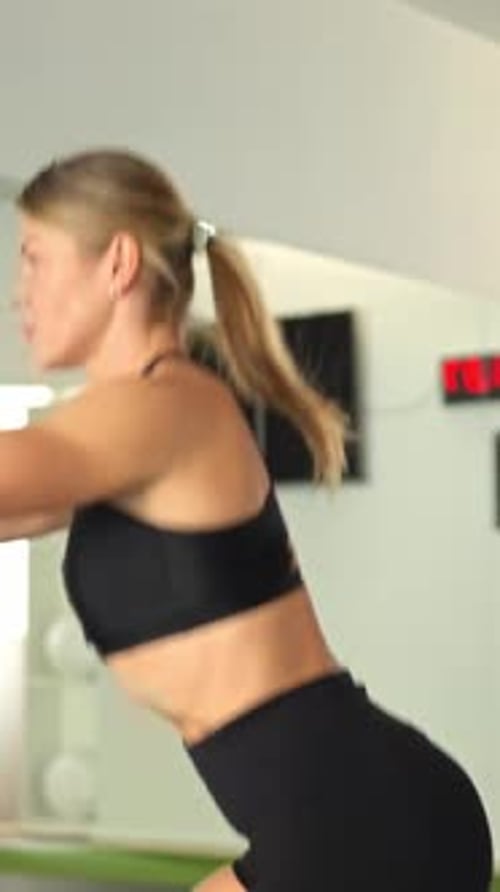 Athletic Woman Performing Squats Exercise in Gym