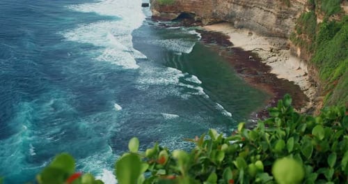 Relájese con vistas al mar con olas anchas de espuma color turquesa que se enrollan en una playa rocosa con aguas cristalinas azules