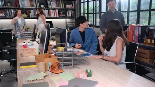 Professionals Collaborating at Desk in Open Office