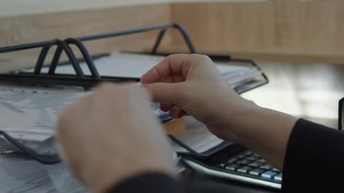 Hand Searching for Document in Office Paper Tray