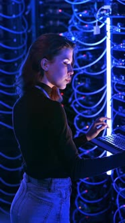 Woman Typing at Server in Data Center