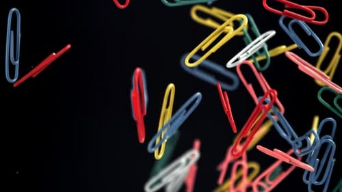 Colorful Paper Clips Falling on Black Background