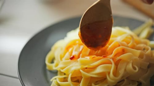 Sauce Being Poured Over Pasta Noodles Close Up