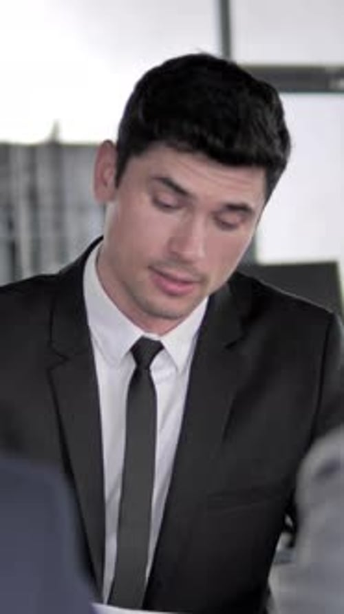 Man in Suit Talking at a Business Meeting