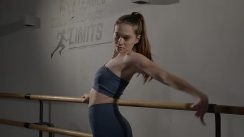 Young Woman Doing Ballet Stretching at Barre