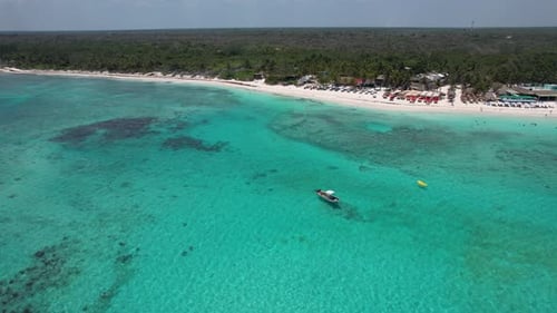 Boats anchored off tropical beach with clear blue water on Caribbean ocean