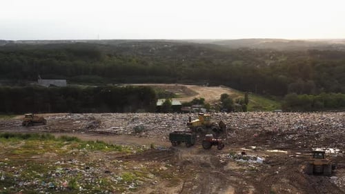 Traktor und Bulldozer auf der Mülldeponie