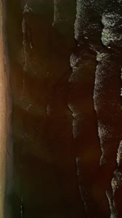 Enjoy the Breathtaking Sight of Dark Ocean Waves Crashing Against a Sandy Shoreline From a