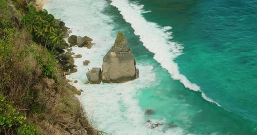 Turquoise ocean water crashes against rocky coast at Diamond Beach on Nusa Penida Island Bali