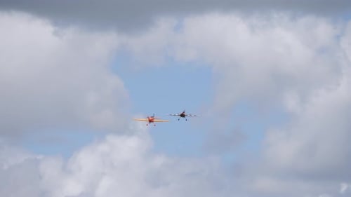 Two acrobatic light aircrafts flying together towards the camera