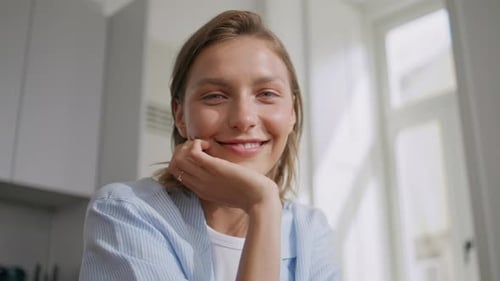 Smiling Young Woman Resting Face in Hand