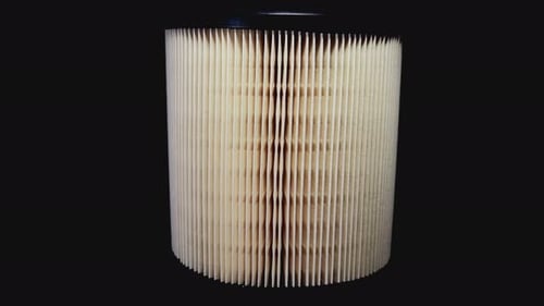 Der
Autoluftfilter dreht sich auf dem Drehteller vor schwarzem Hintergrund.