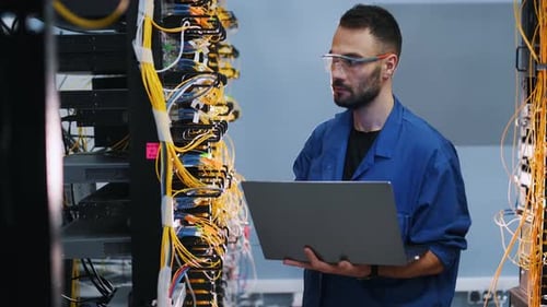 IT Engineer Working with Laptop in Data Center