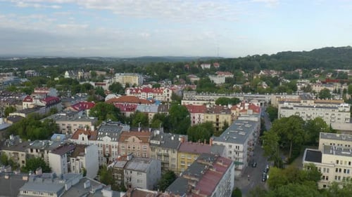 Aerial drone forward moving shot over residential buildings in Krakow, Cracow in Poland along hilly