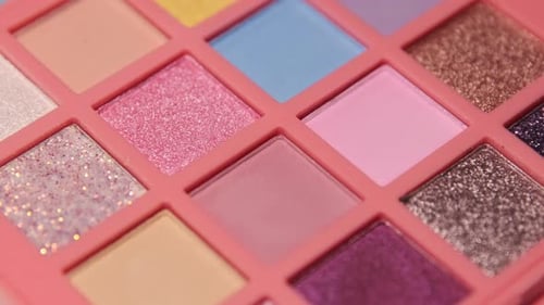 Make up eyeshadow multicolor palette illuminated by light and immersed in darkness.