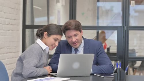 Business Colleagues Collaborating on a Laptop in Office
