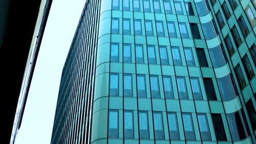 Tall glass buildings, glazed office buildings reflect the sky and clouds in the glass, green color o