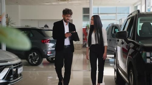 Muslim Car Salesman Showing Vehicles to Potential Buyer in Dealership