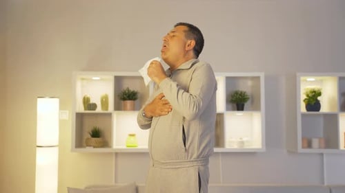 Homme qui se couvre la bouche et le nez en toussant.
