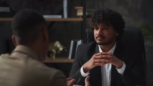 Businessmen Discussing a Contract in an Office