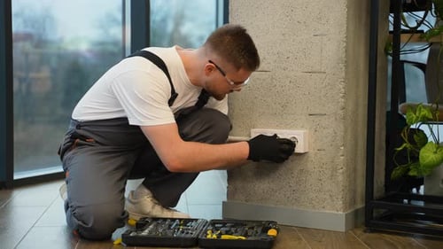 Young Man Installing Electrical Socket in Wall