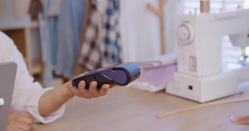 Costureira sênior asiática estende a máquina POS para clientes adultos para obter cartão de crédito com toque sem contato