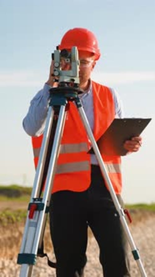 Surveyor Using Theodolite for Measurement on Construction Site