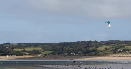 long shot of mount Bay beach at low tide with kite surfer in the air