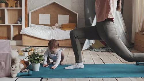 Mom Stretching In Nursery, Baby Playing With Plant Beside, Morning