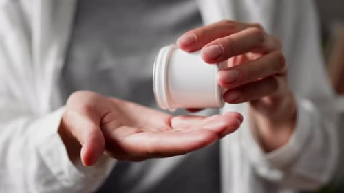 Female Hands Pour Out Pills From A Bottle Box, Close Up Capsule Pills Fall Into The Palm Of The Hand