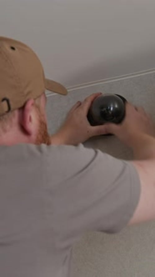 Man Installing Security Camera Indoors