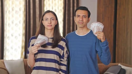 Couple Holding Money at Home