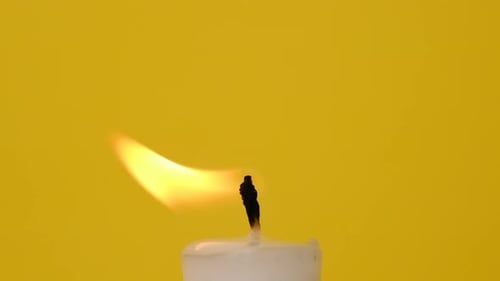 Close Up of Candle Flame Burning on Yellow