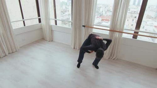 Young Adult Stretching at Barre in Dance Studio