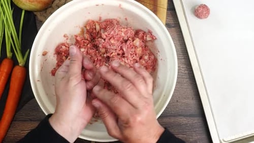 Hands Forming Meatballs at the Kitchen Table