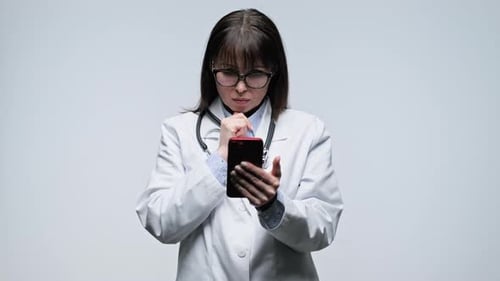 Female Doctor Using Smartphone in Clinic