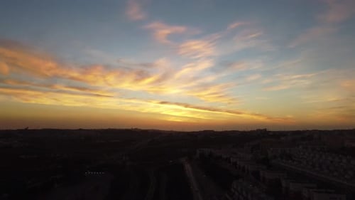 Very slow shot on a drone facing an amazing sunset over a city in Portugal.