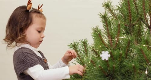 Happy Little Child Girl Decorating Christmas Tree