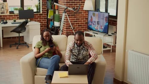 Couple Relaxing on Couch with Technology in Living Room